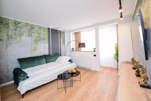 um quarto com um sofá verde e uma mesa em One by One - by Grand Accommodation em Bucareste