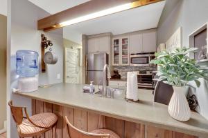 a kitchen with a counter with chairs and a sink at Harbor Cove Shores in Harbor Springs