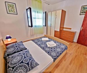een slaapkamer met een bed met een zwart-wit dekbed bij Apartman Irena with terase end private parking in Okrug Donji