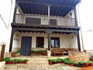 a house with a balcony and a patio with plants at El Almez 2 Casa rural 