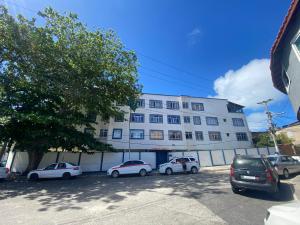 a large white building with cars parked in front of it at Rental Home Praia Grande in Arraial do Cabo