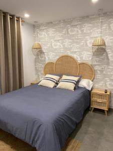 ein Schlafzimmer mit einem großen Bett mit blauer Bettwäsche und einer Wand in der Unterkunft Barraña Guest House in Boiro