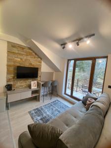 a living room with a large couch and a fireplace at Apartmani Srna Milmari in Kopaonik