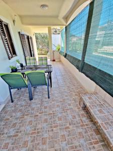 a patio with tables and chairs on a brick floor at Apartman Irena with terase end private parking in Okrug Donji