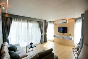 a living room with a couch and a tv at Le Breeze Resort Hua hin in Cha Am