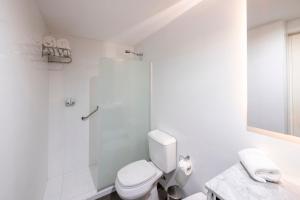 a white bathroom with a toilet and a shower at Top Rentals Montañeses in Buenos Aires
