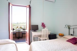 um quarto com uma cama e uma secretária com um computador em Baja Azzurra em Bari Sardo