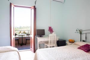 a bedroom with a bed and a desk with a computer at Baja Azzurra in Bari Sardo