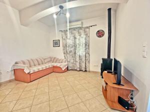 uma sala de estar com um sofá e uma televisão em Apartman Irena with terase end private parking em Okrug Donji
