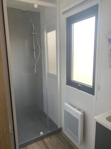 a glass shower in a bathroom with a window at Camping les Lacs d'Armagnac in Bretagne-dʼArmagnac