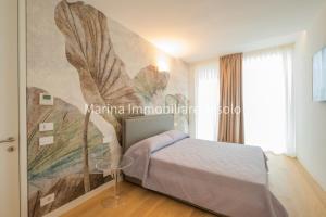 a bedroom with a bed and a painting on the wall at THE SUMMER HOUSES in Lido di Jesolo +81 photos