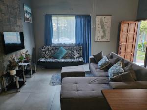sala de estar con sofá y ventana en Le Grix Guesthouse, en Nelspruit