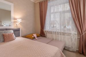 ein Schlafzimmer mit einem Bett und ein Fenster mit einem Teddybär in der Unterkunft Joya Mia - the soul of Riga & free parking in Riga