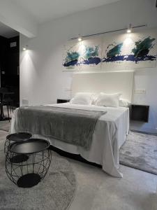 a bedroom with a large white bed with two chairs at Dama modern & luxury in Málaga