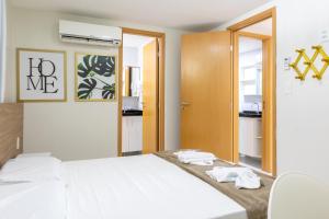 una camera da letto con un letto bianco e uno specchio di Ocean Resience a Porto De Galinhas Altre 44 foto