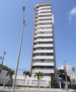 un grand bâtiment avec une clôture devant lui dans l'établissement Apartamento em Fortaleza, Abolição Mucuripe, à Fortaleza