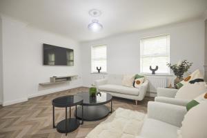 ein Wohnzimmer mit einem Sofa und einem Tisch in der Unterkunft Luxurious and Modern 3 Bed townhouse with Parking in Norwich