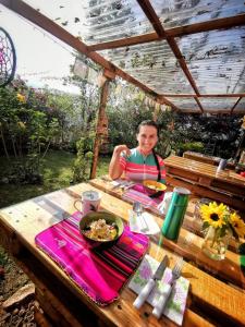 a woman sitting at a picnic table with a plate of food at Refugio Explora Verde in Choachí +37 photos