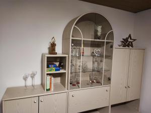 a large white cabinet with glasses in it at Apartment "Zur Rotbuche" in Lindau