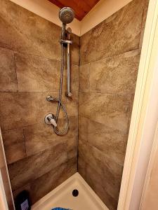 a shower in a bathroom with a stone wall at LA CASA DEL SOLE in Merone