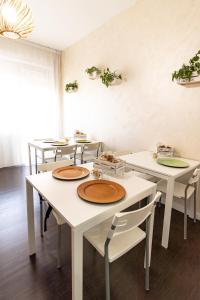 una stanza con tavoli e sedie con piatti di Elisir B & B a Pescara