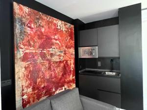 uma cozinha com uma pintura vermelha na parede em Eneldo modern & luxury em Málaga