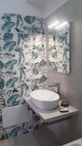 a bathroom with a sink and a blue and white wallpaper at Casa Aurora in Taormina