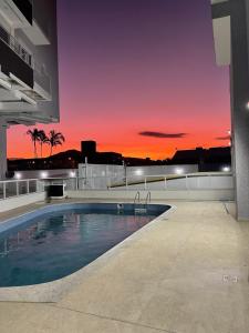 una piscina en la parte superior de un edificio con puesta de sol en welcome to our home sweet home, en Florianópolis