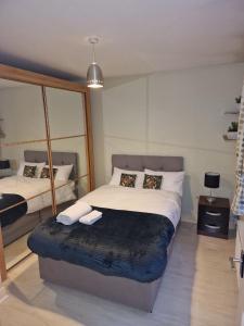 a bedroom with a large bed and a mirror at Sunny House in Haydock