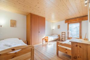 um quarto com 2 camas e um tecto de madeira em CT em Verbier