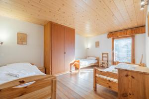Un dormitorio con dos camas y techo de madera. en CT, en Verbier