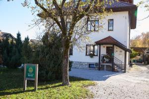 a house with a sign in front of it at Apartmaji Koman in Bled