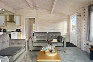 a living room with two couches and a table at Chestnut, 6 Fingle Glen Lodges in Holcombe Burnell
