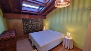 a bedroom with a white bed and a skylight at Casa Vacacional La Portillina in La Portilla