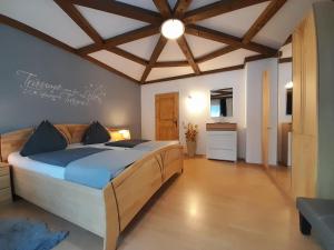 - une chambre avec un grand lit et un plafond en bois dans l'établissement Haus Rosina, à Mühlbach am Hochkönig