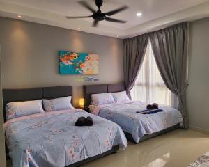 a bedroom with two beds and a ceiling fan at Bali Residence Impian Raudah in Melaka