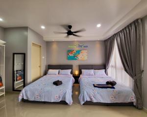 a bedroom with two beds and a ceiling fan at Bali Residence Impian Raudah in Melaka