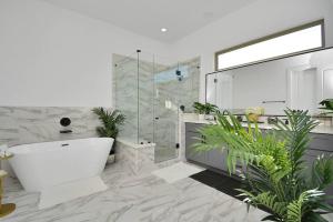 un baño con bañera y ducha de cristal en Blissful Getaway Home with Hot Tub & Backyard Near Downtown, en Houston 48 fotos más