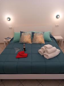 Una cama azul con toallas y almohadas. en AnSè 2.0, en Polignano a Mare
