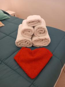 Una cama con toallas y un corazón rojo. en AnSè 2.0, en Polignano a Mare