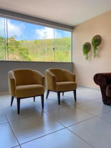 2 sillas en una sala de espera con ventana en Ap 2 quartos em Ipiabas, en Barra do Piraí
