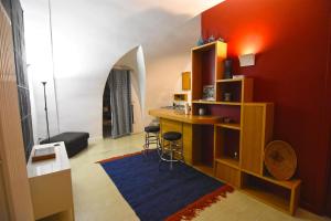 ein Wohnzimmer mit einem Schreibtisch und einer roten Wand in der Unterkunft La Maison d'Adele in Neapel