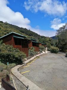 een gebouw met een parkeerplaats naast een berg bij Lauraceas Lodge in San Gerardo de Dota