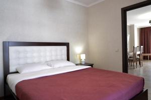 a bedroom with a large bed with a red blanket at Villa Gor Apartments in Bukovel