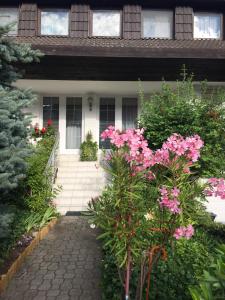 uma casa com flores cor-de-rosa em frente em Anna Vendégház Eger em Eger