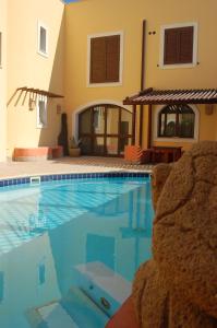 a swimming pool in front of a house at El Mosaico Del Sol in Lampedusa