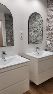 a bathroom with two sinks and two mirrors at Cíes Luxury Suitel Lily Rodsen - Love your Stay in Vigo