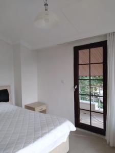 シダにあるGülce Family Aparthotelのベッドルーム1室(ベッド1台付)、スライド式ガラスドアが備わります。