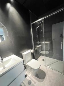 a bathroom with a toilet and a shower and a sink at Hostel Faro Málaga modern & luxury in Málaga