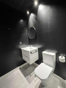 a bathroom with a white toilet and a sink at Hostel Faro Málaga modern & luxury in Málaga